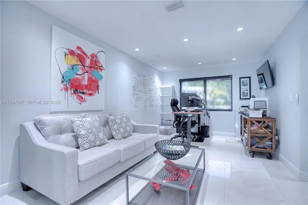a living room with furniture and kitchen view