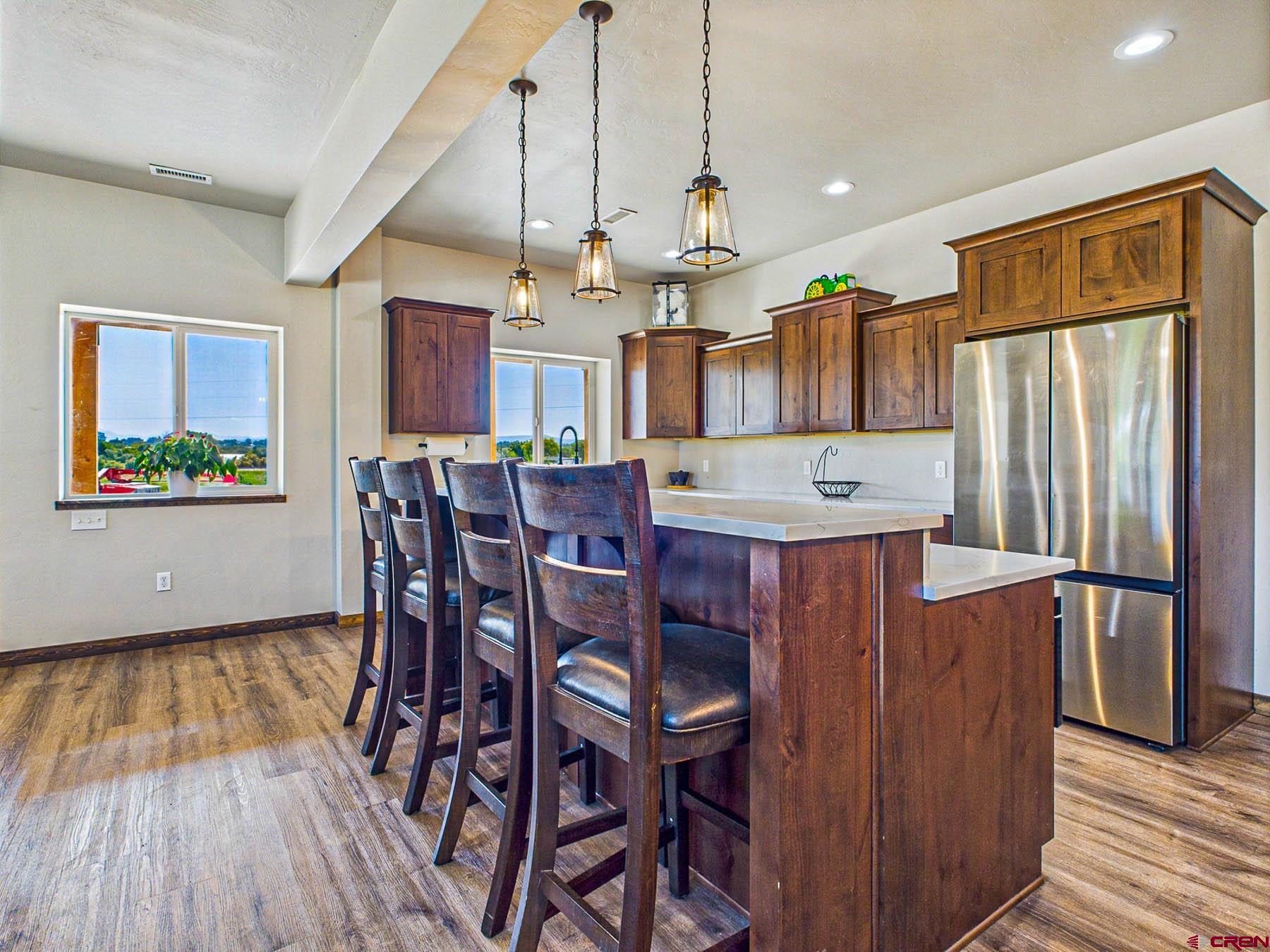 14885 G Road Delta, CO 81416 - Photo 12 of 45 a view of a kitchen with stainless steel appliances granite countertop a refrigerator a stove a microwave oven a dining table and chairs with wooden floor