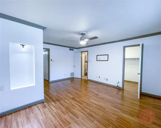 a view of empty room with wooden floor
