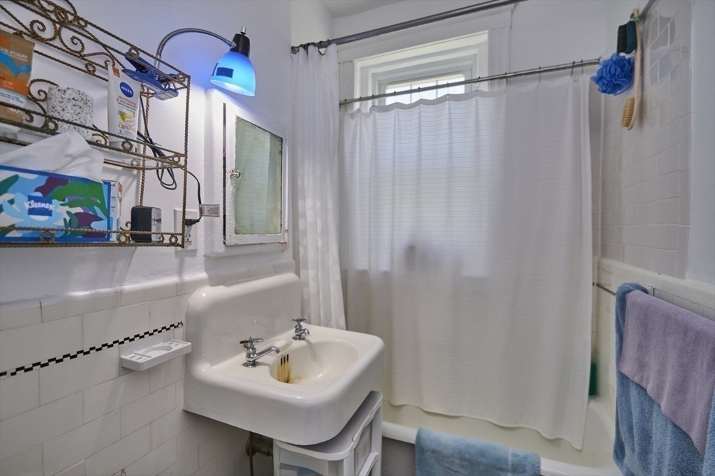 15 Colliston Road, Unit 6 Boston, MA 02135 - Photo 12 of 17 a bathroom with a sink a mirror and a shower
