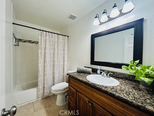 7304 Exeter Street, Unit E Paramount, CA 90723 - Photo 21 of 36 Upstairs hall full bath featuring matching cabinetry throughout the home, tile flooring, granite countertops, and a beautifully detailed inlay within the shower.