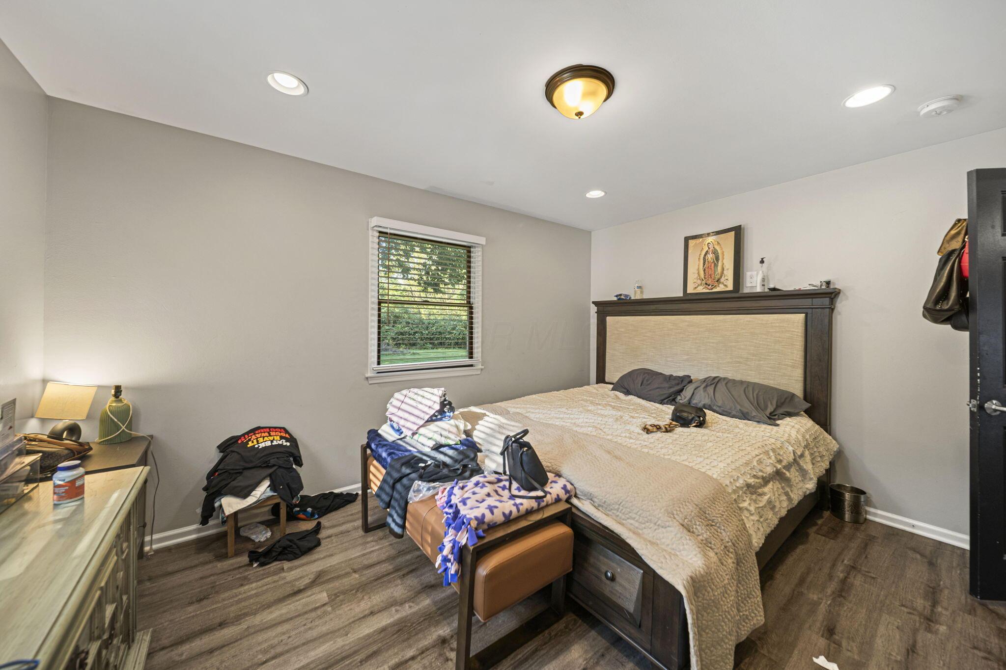6344 Post Road Dublin, OH 43017 - Photo 22 of 45 Recessed ceiling lighting, a window with horizontal blinds, wood-finish flooring, and a dark-paneled door with dark hardware