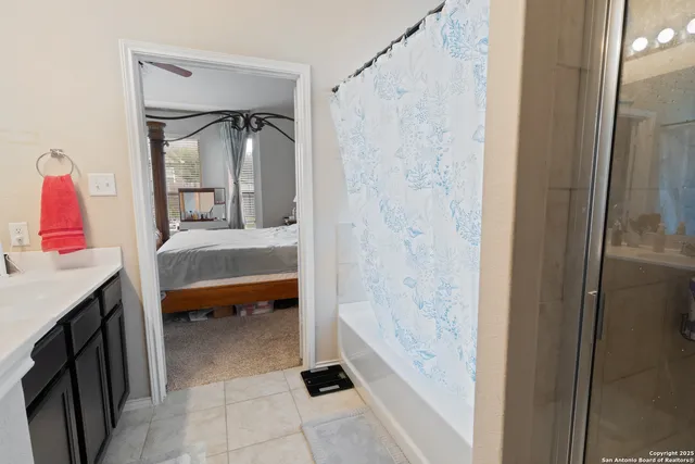 a bathroom with a bathtub sink vanity and mirror
