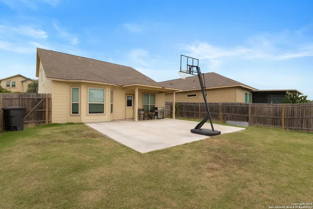 a backyard of a house with table and chairs