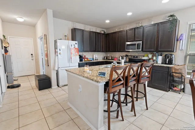 a kitchen with stainless steel appliances a refrigerator sink stove microwave and cabinets