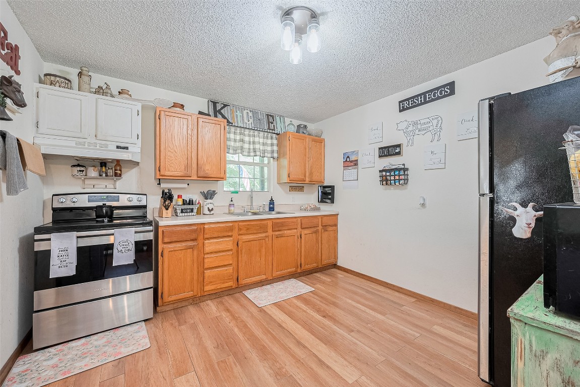 200 Little Pine Valley Road Cleveland, TX 77328 - Photo 20 of 43 a kitchen with stainless steel appliances granite countertop a stove a sink and a refrigerator
