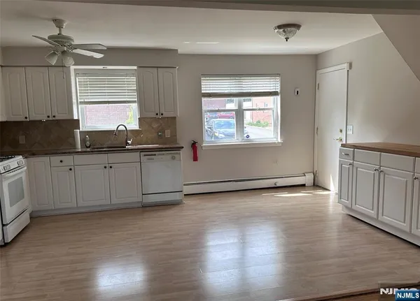 a kitchen with stainless steel appliances granite countertop a sink cabinets and wooden floor
