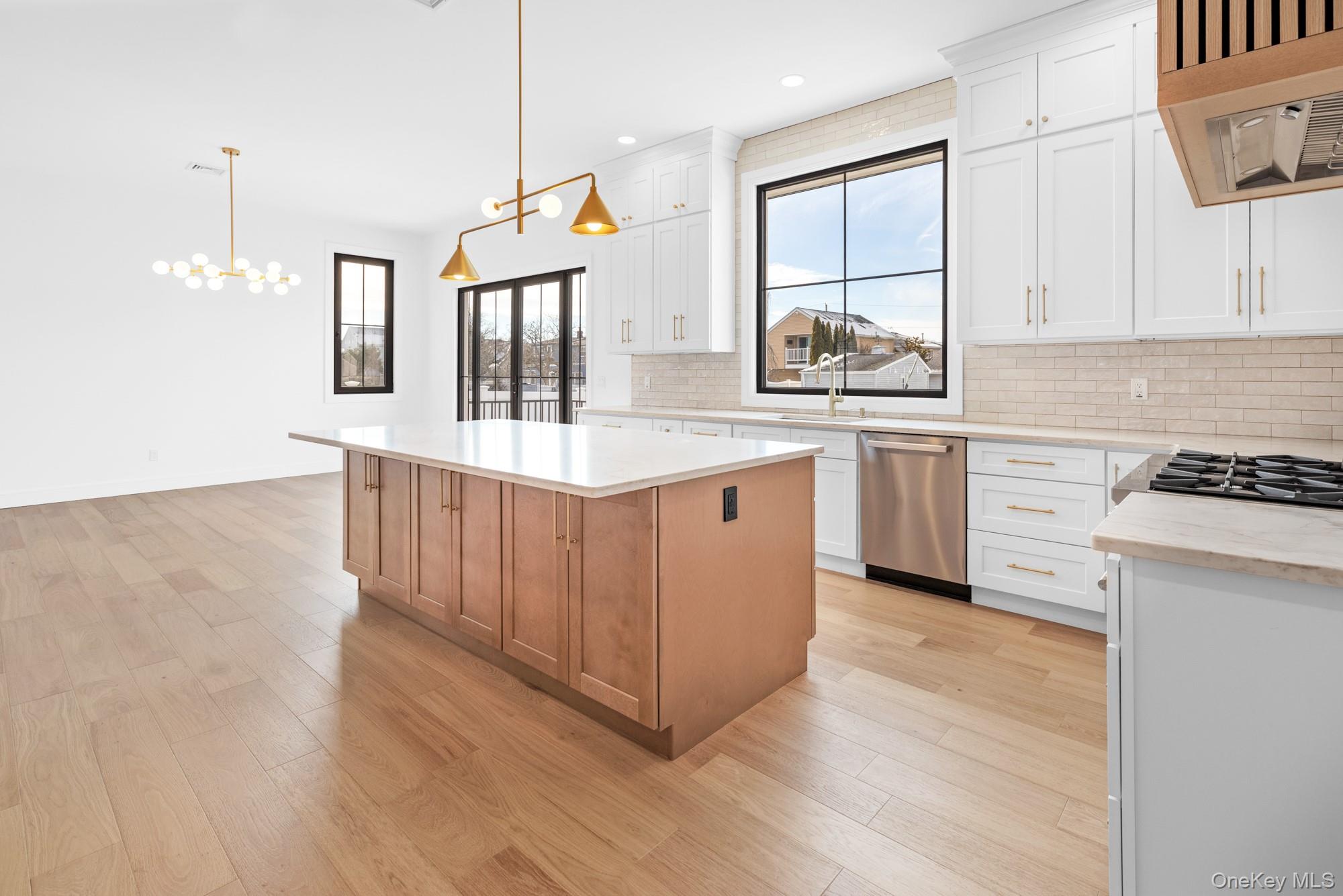 24 Midway Street Babylon, NY 11702 - Photo 13 of 40 Kitchen featuring decorative backsplash, white cabinetry, pendant lighting, and recessed lighting