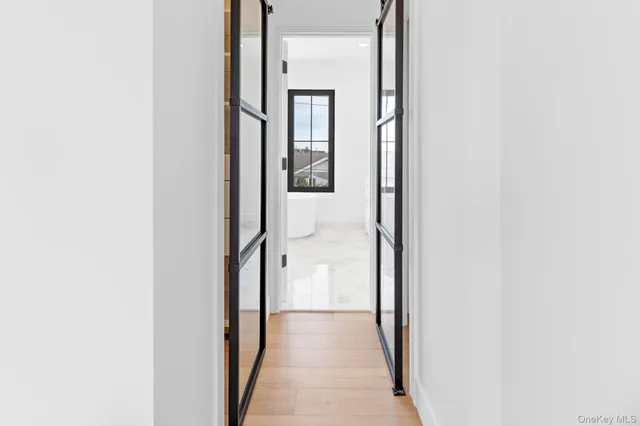 a view of a hallway with wooden floor and staircase