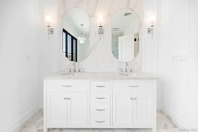 a bathroom with a double vanity sink and a large mirror