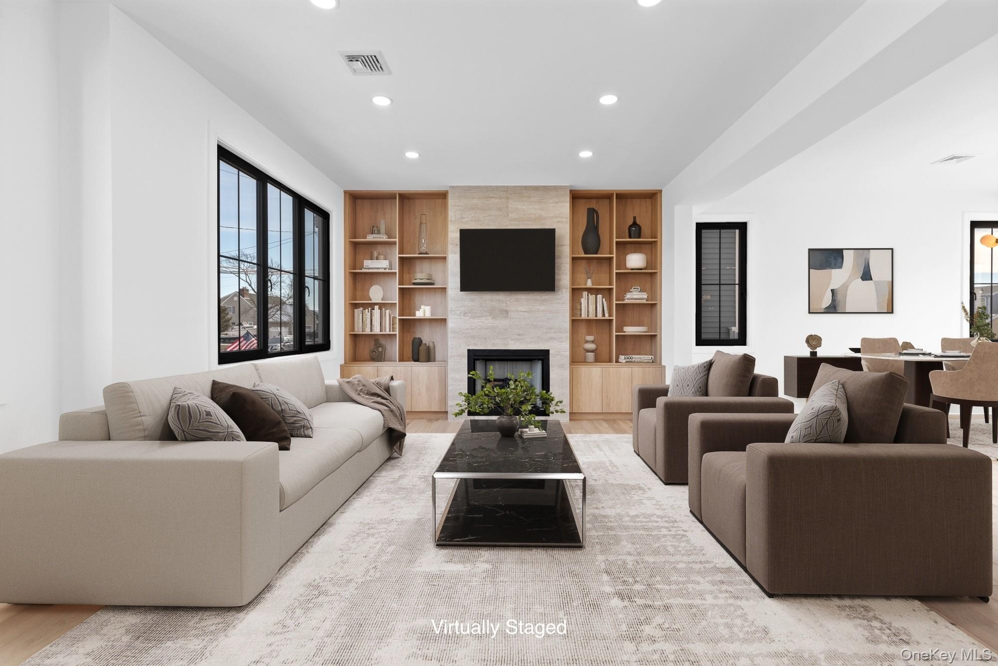 24 Midway Street Babylon, NY 11702 - Photo 7 of 40 Living area featuring a large fireplace, built in shelves, recessed lighting, and light wood-style floors