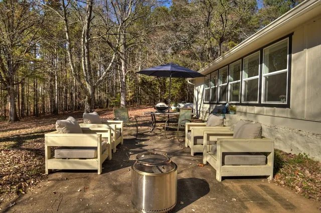a view of a patio with table and chairs under an umbrella