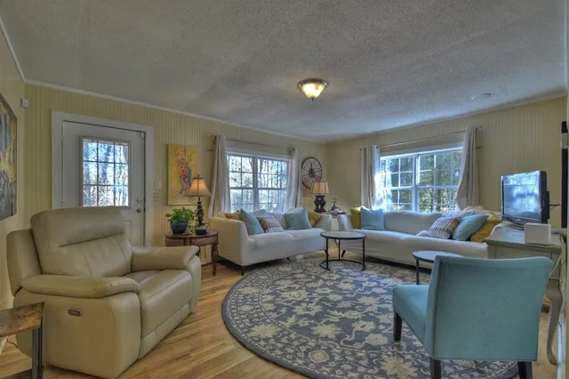 a living room with furniture wooden floor and a window
