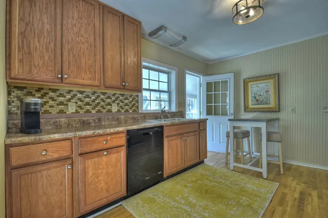 a kitchen with granite countertop cabinets stainless steel appliances a sink and a window