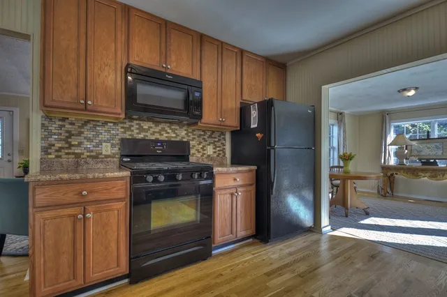 a kitchen with granite countertop wooden cabinets and dining table