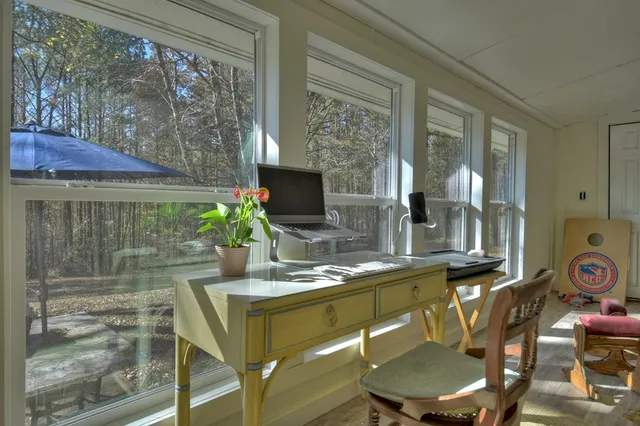 a view of a dining room with furniture large windows and wooden floor