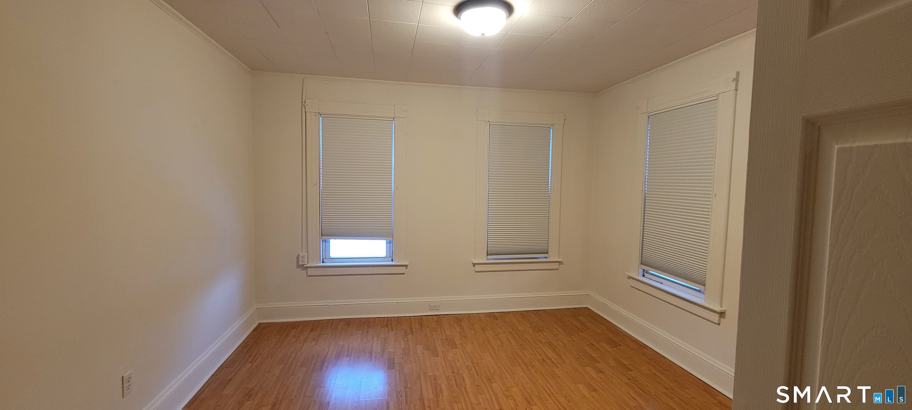 130 Church Street Bristol, CT 06010 - Photo 17 of 22 a view of an empty room with wooden floor and a window