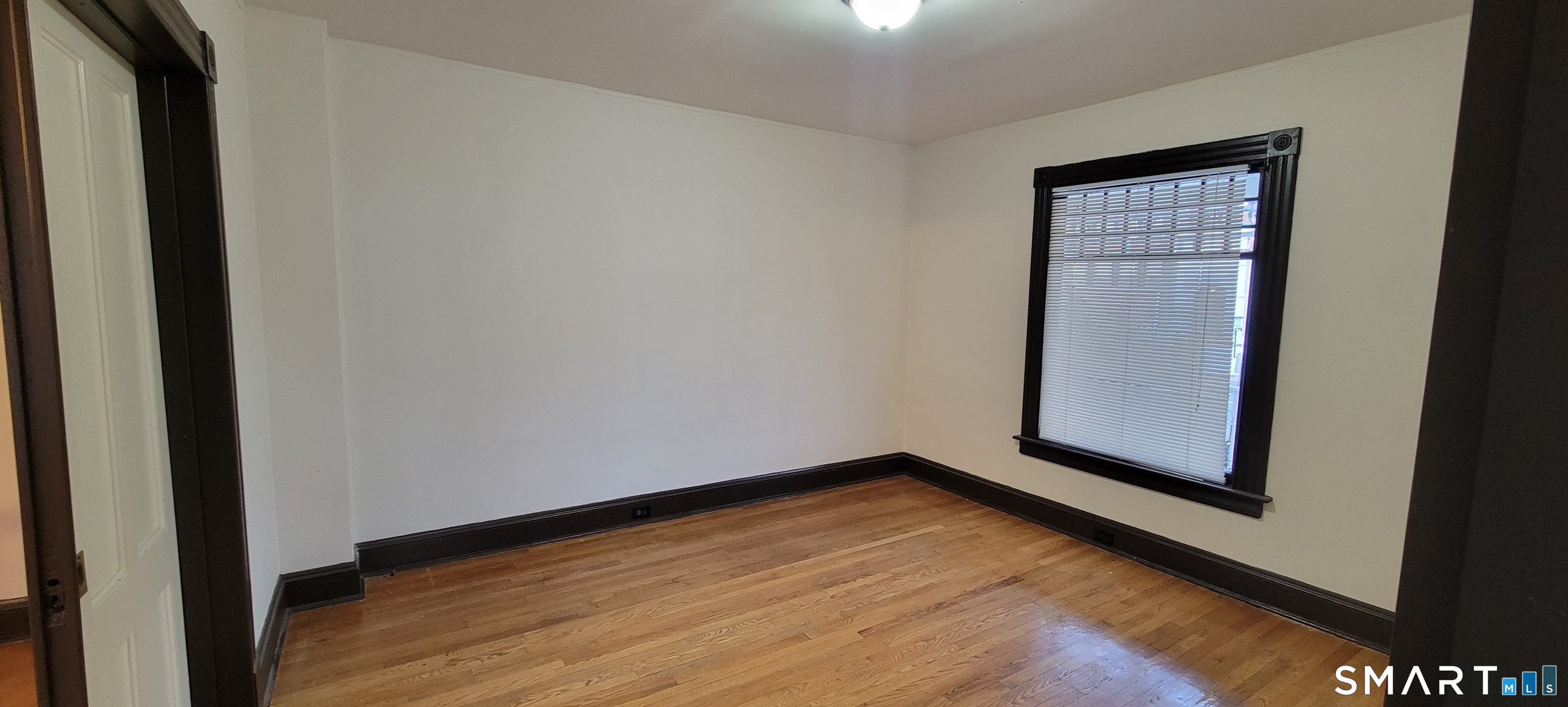 130 Church Street Bristol, CT 06010 - Photo 4 of 22 a view of an empty room with wooden floor and a window