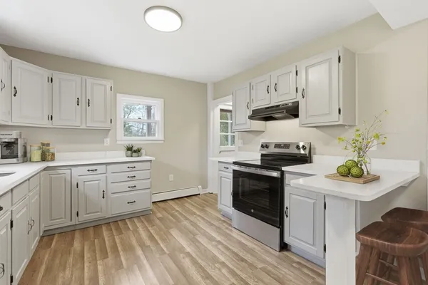 a kitchen with white cabinets and appliances