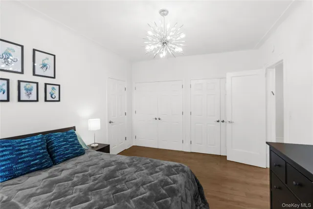 a bedroom with a large bed and a chandelier