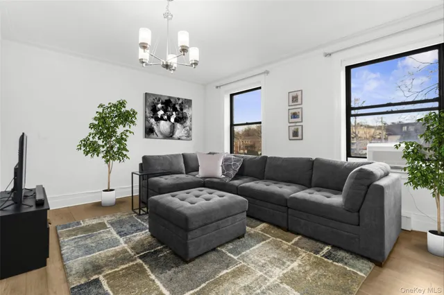 a living room with furniture a chandelier and a window