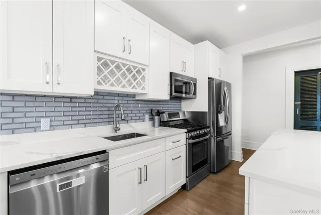a kitchen that has a sink cabinets stainless steel appliances and a window