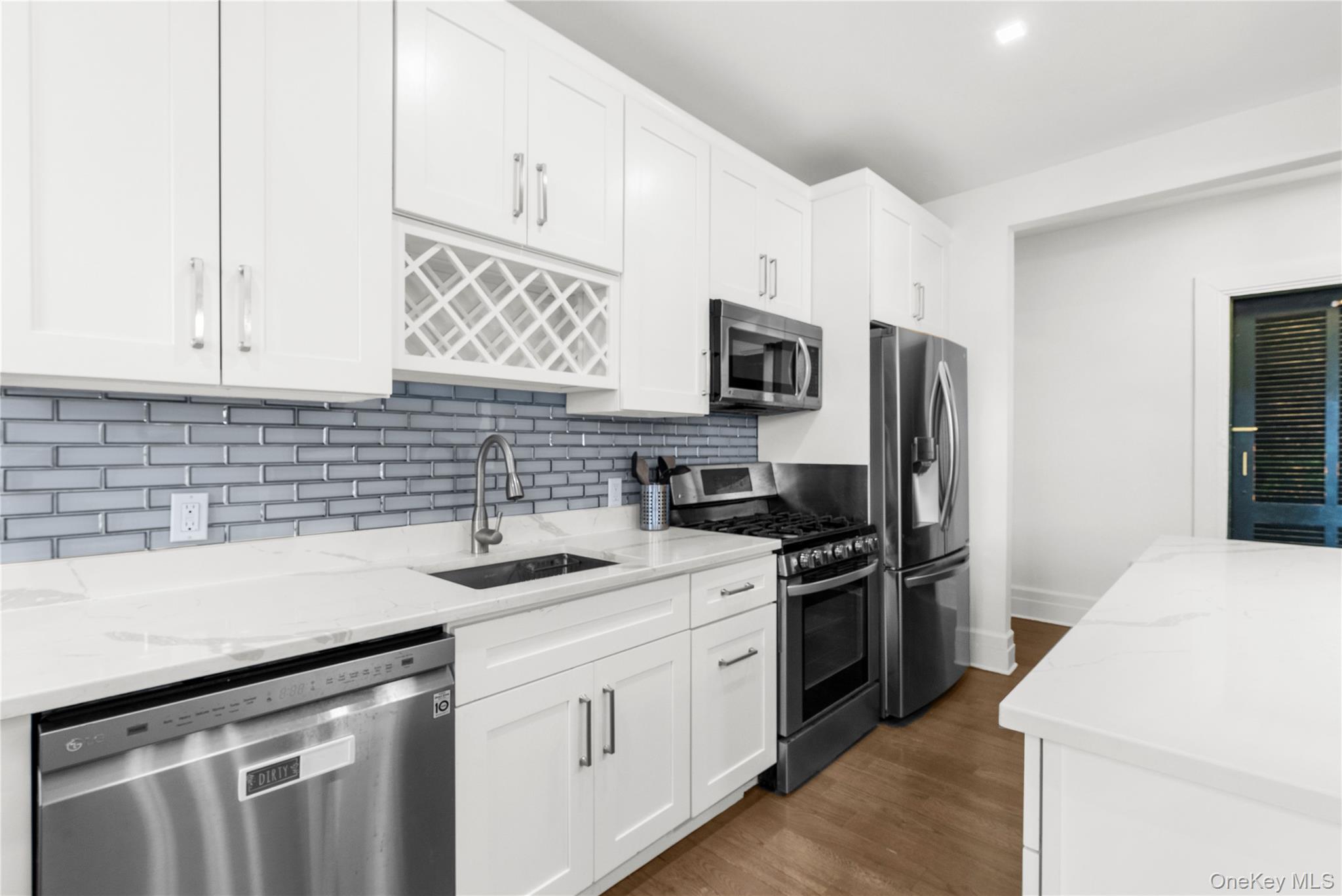 37 Brompton Road, Unit 3D Great Neck, NY 11021 - Photo 9 of 18 a kitchen that has a sink cabinets stainless steel appliances and a window