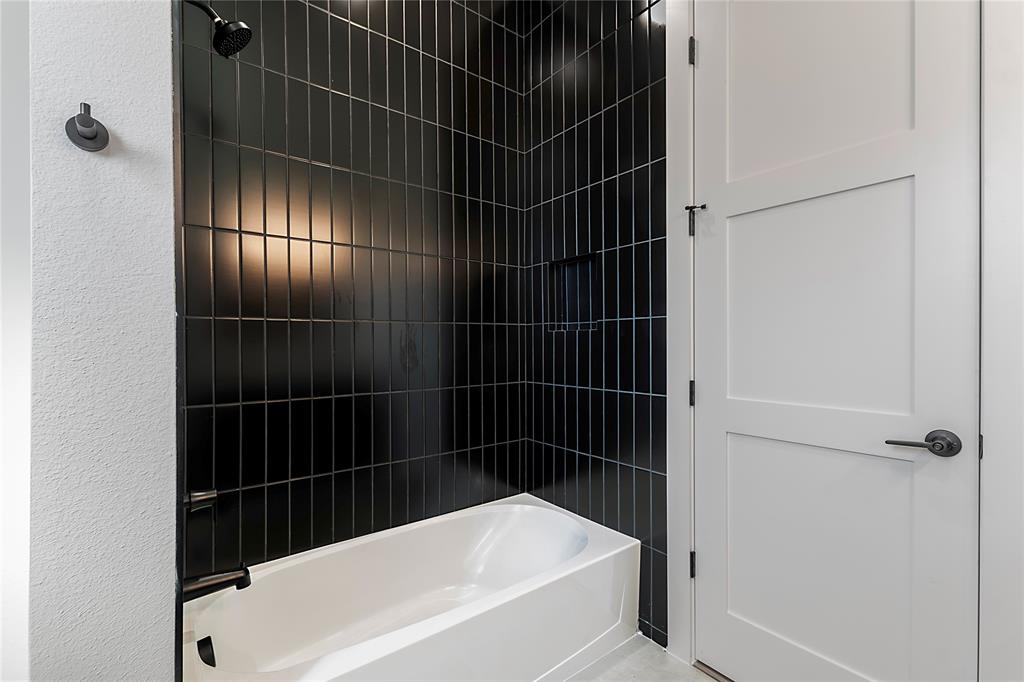 430 Whispering Way Red Oak, TX 75154 - Photo 32 of 40 Bathroom featuring a white tub with dark hardware, black subway tile surround, and a built-in shower niche