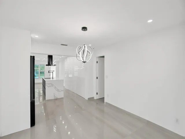 a view of a kitchen with refrigerator and white cabinets