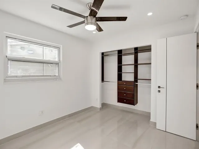 a view of an empty room with cabinet and a window