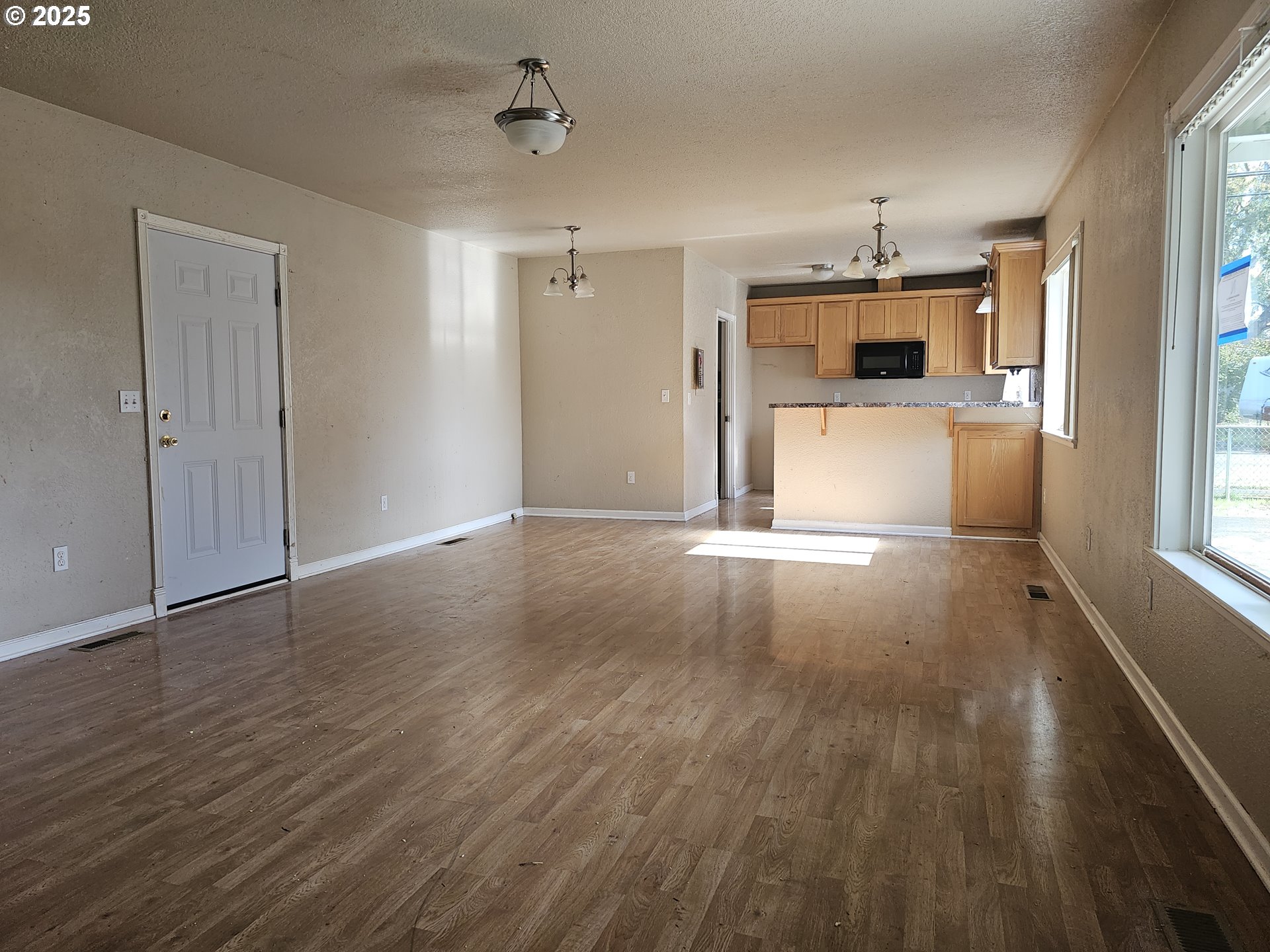 183 East Dodge Street Lebanon, OR 97355 - Photo 3 of 21 a view of empty room with wooden floor and window