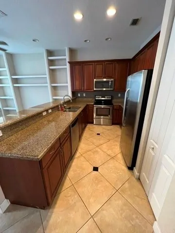 a kitchen with stainless steel appliances granite countertop a sink stove and refrigerator