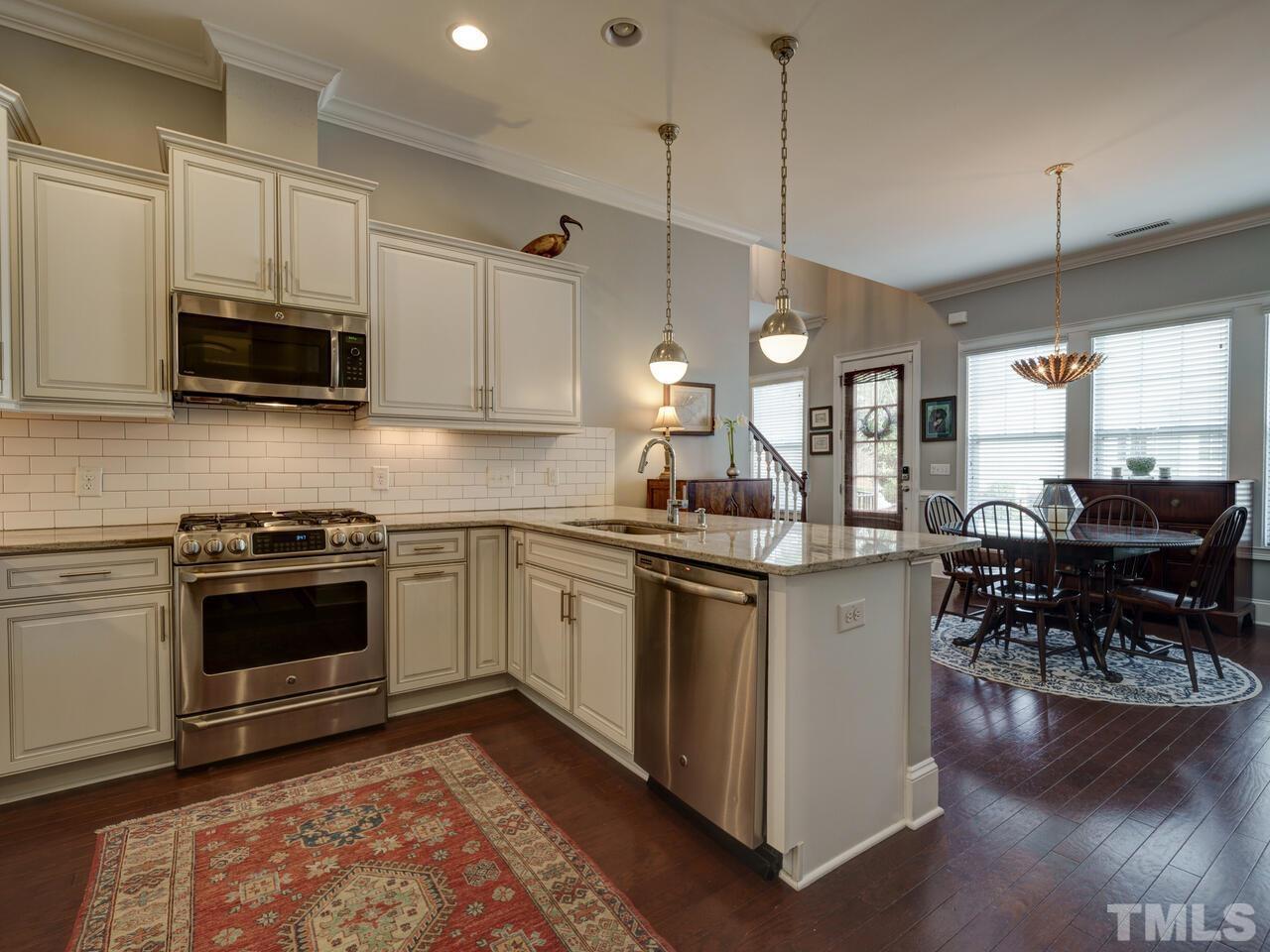 500 Deodar Lane Raleigh, NC 27608 - Photo 11 of 49 a kitchen with stainless steel appliances granite countertop a stove a sink and a microwave