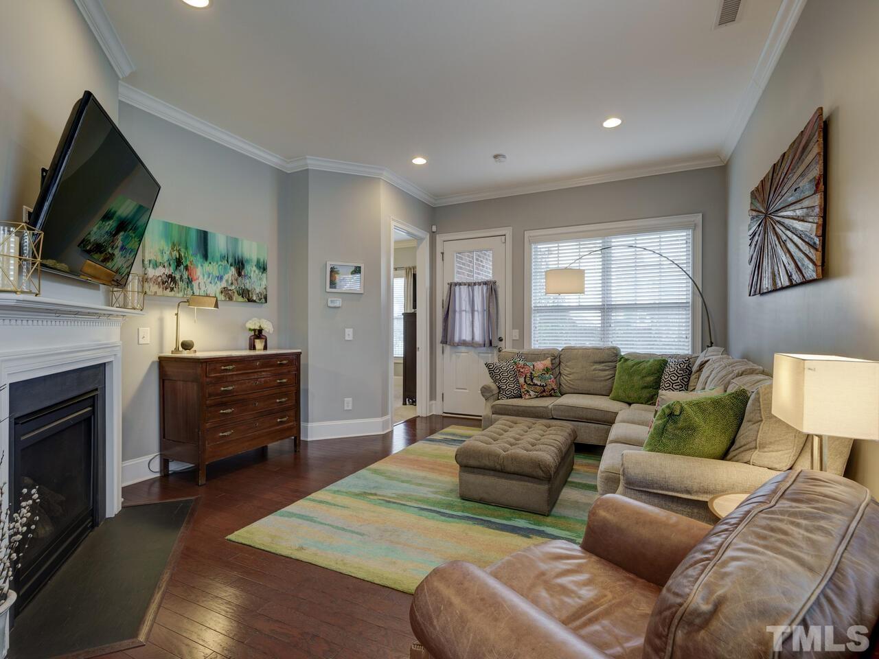 500 Deodar Lane Raleigh, NC 27608 - Photo 17 of 49 a living room with furniture a flat screen tv and a fireplace