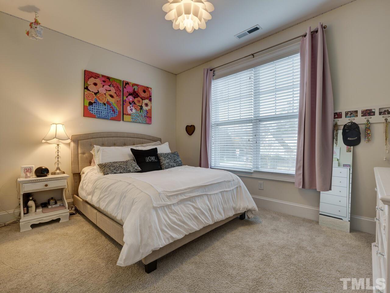 500 Deodar Lane Raleigh, NC 27608 - Photo 24 of 49 a bedroom with a bed and a chandelier