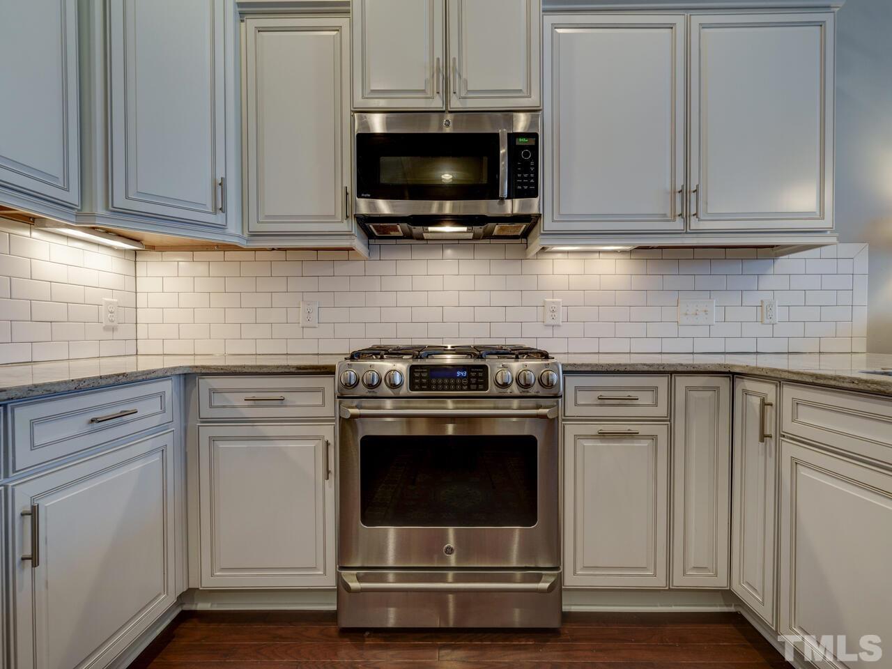 500 Deodar Lane Raleigh, NC 27608 - Photo 9 of 49 a kitchen with stainless steel appliances granite countertop a stove and a microwave