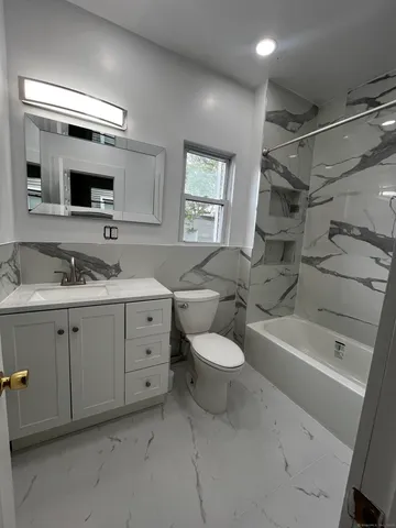 a spacious bathroom with a double vanity sink a mirror and a bathtub