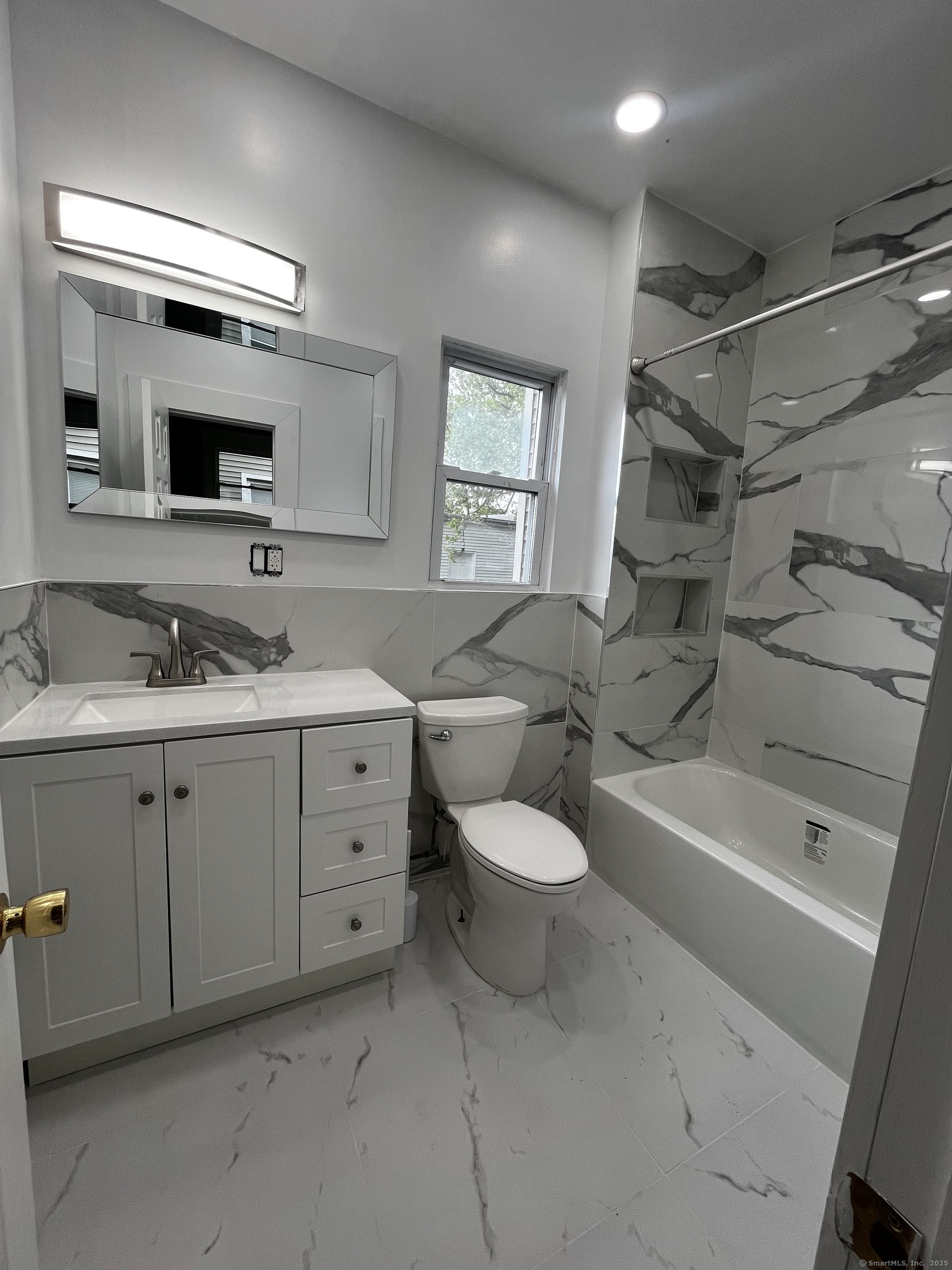 a spacious bathroom with a double vanity sink a mirror and a bathtub
