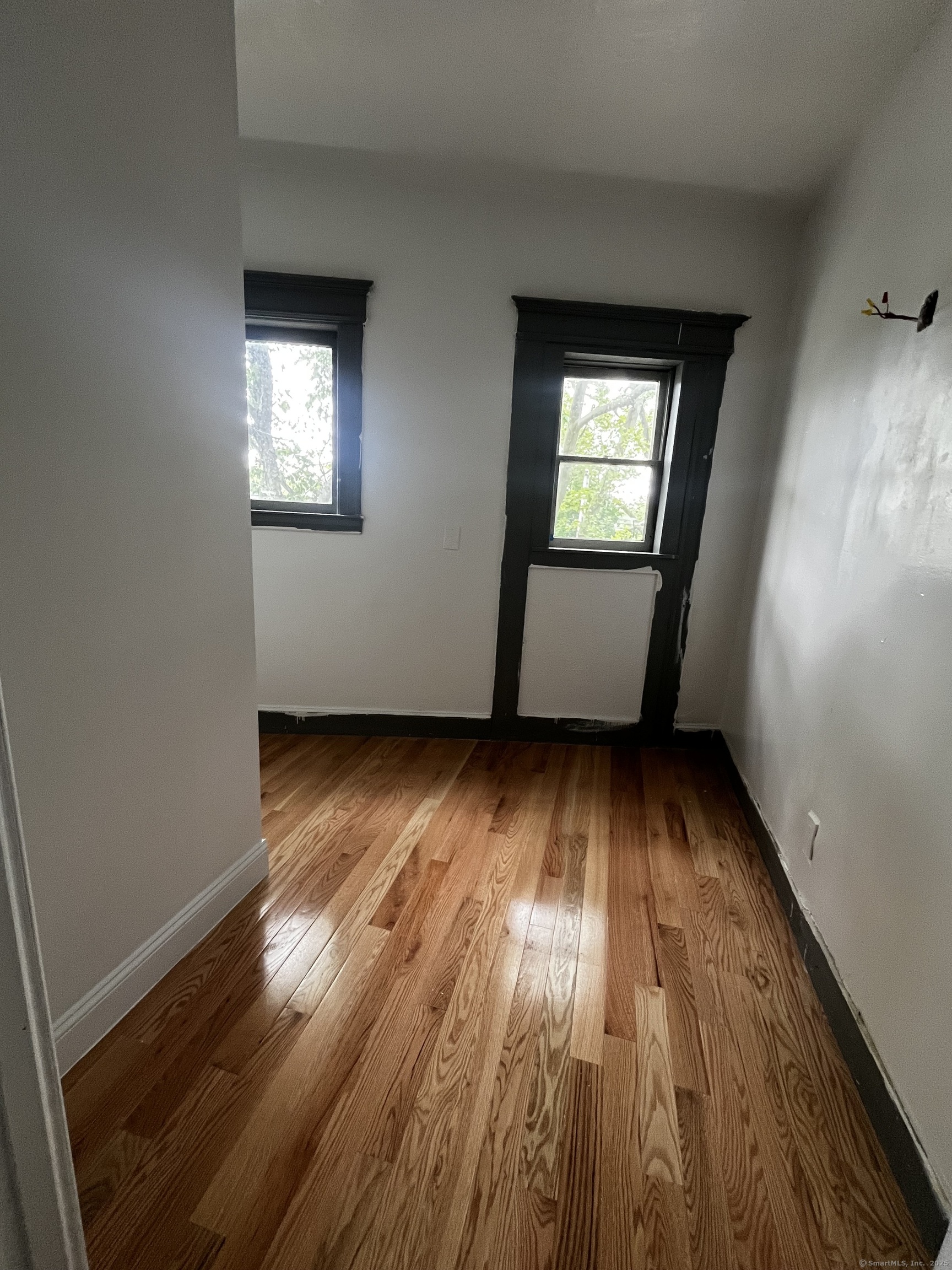 11 Truman Street, Unit 2 New Haven, CT 06519 - Photo 3 of 7 an empty room with wooden floor and windows