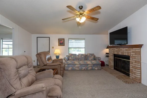 a living room with furniture a flat screen tv and a fireplace