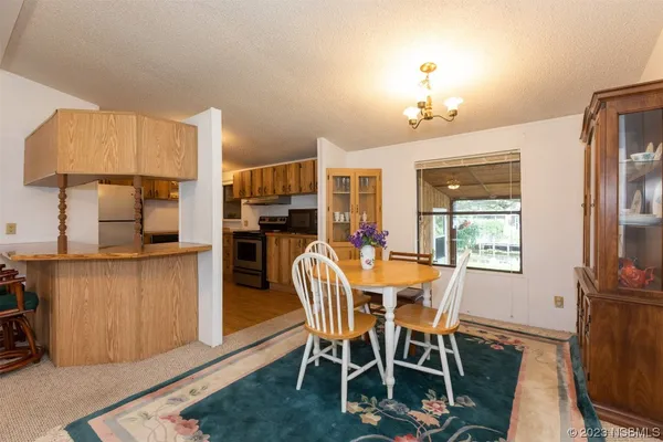 a dining room with furniture a chandelier and wooden floor