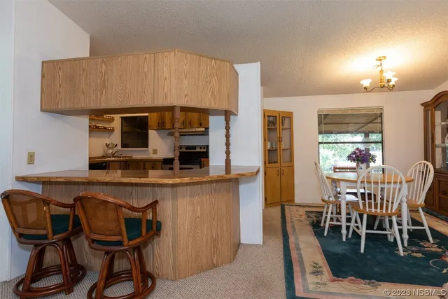 a kitchen with stainless steel appliances a dining table chairs and granite counter tops