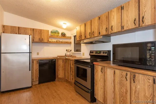 a kitchen with stainless steel appliances granite countertop a stove a refrigerator and a microwave
