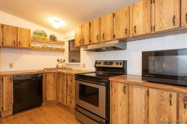 a kitchen with stainless steel appliances granite countertop a stove and a microwave