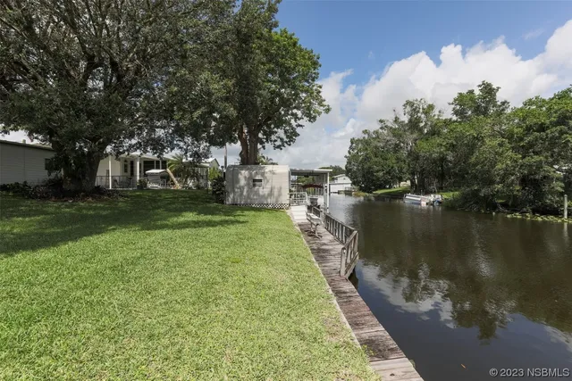 a backyard of a house with lots of green space and lake view