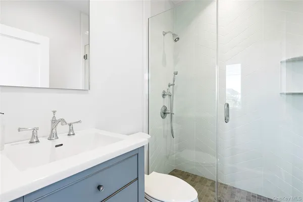 a bathroom with a sink a toilet and shower