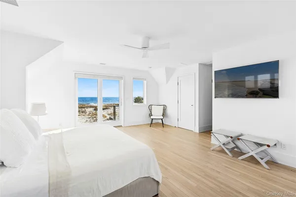 a spacious bedroom with a bed and a flat screen tv