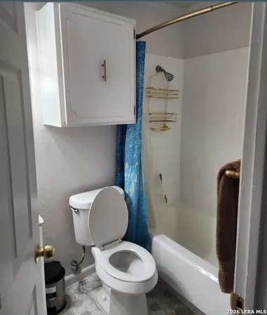 a white toilet sitting next to a bathroom sink and a shower