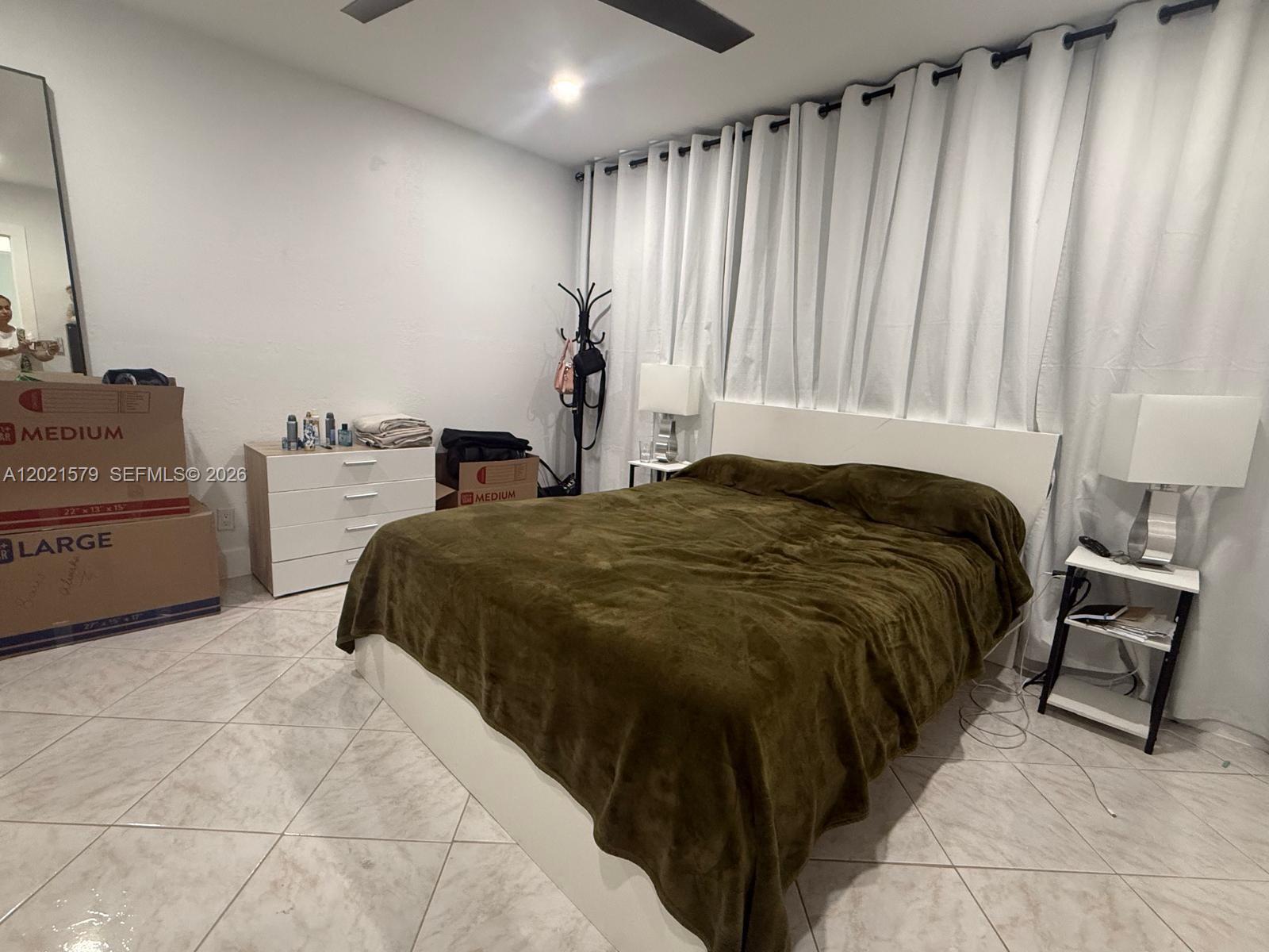 22445 Southwest 264th Street Homestead, FL 33031 - Photo 8 of 12 a bedroom with a bed and a mirror