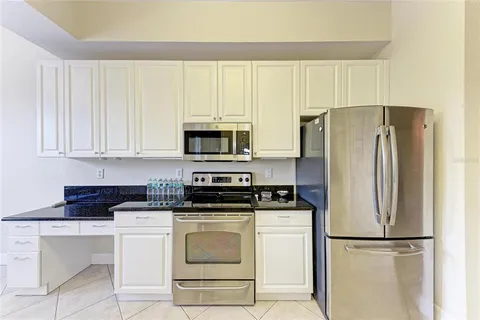 a kitchen with a sink a stove and chairs